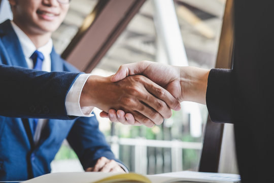 Finishing up a meeting, handshake of two happy business people after contract agreement to become a partner, collaborative teamwork