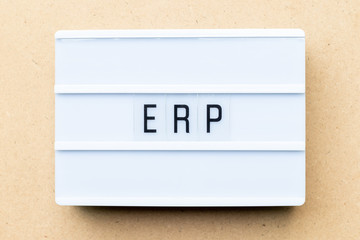 White lightbox with word ERP (Abbreviation of Enterprise Resource Planning) on wood background