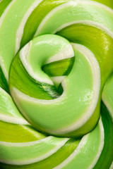 close up view of swirl green delicious shiny sweet lollipop