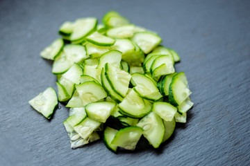 Sliced fresh cucumbers on a black background.