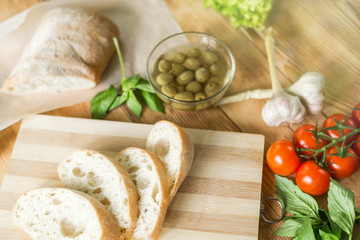 Sliced bread, ciabatta on wooden background. Preparation for the preparation of bruschetta.