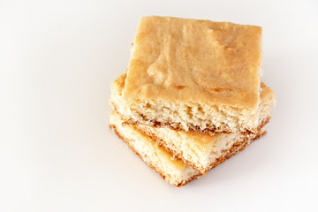 Stack of square pieces lemon shortbread cake isolated white background. Selective focus.