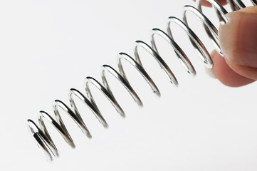 Metal spring in hand isolated on white background