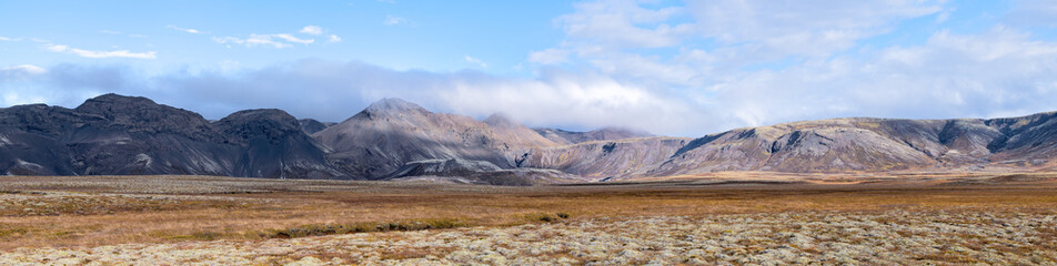 Fototapeta na wymiar Landscape panoramic panorama view of Laugarvatn mountains with clouds covering on golden circle in Iceland during day and blue color sky in autumn