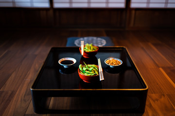 Traditional japanese machiya house or ryokan restaurant with black lacquered wood table and edamame...