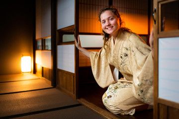 Traditional japanese house or ryokan with gaijin caucasian woman in kimono and tabi socks opening...