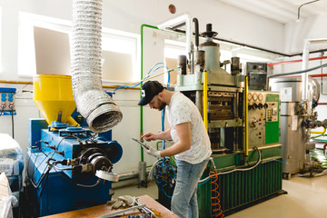 Young man working in a vinyl factory	