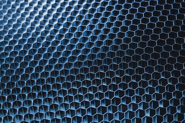 Blue metallic honeycomb grid texture pattern. dark background