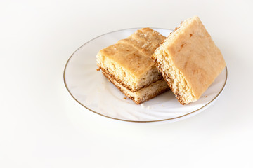 Stack of square pieces lemon cake isolated white background. Selective focus.