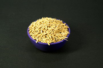 One bowl of paddy seeds on black background
