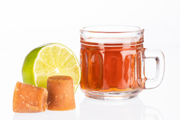 Fresh homemade Aguapanela, Agua de Panela or Aguadulce, a popular Latin American sweet drink made of panela unrefined whole cane sugar boiled in water, served warm or cold with lime.