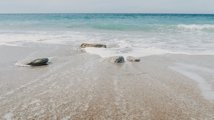 breaking wave at the shore with clear water