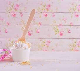 Vanilla ice cream with white chocolate on the white table and floral background. Copy space.