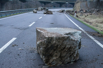 rockfall on the mainroad in dolomites area, northern Italy.  Big boalder on the road. danger zone