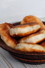 Potato pies on a ceramic dish opposite light background