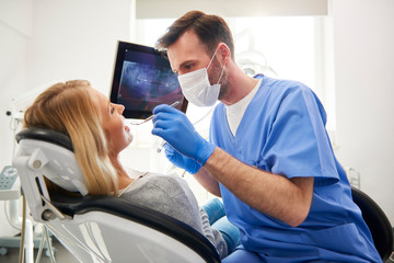 Side view of stomatologist doing his work in dentist's clinic