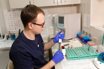 laboratory assistant analyzing a blood sample using micropipette