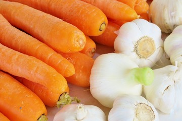 ripe orange carrots and garlic close up on white background