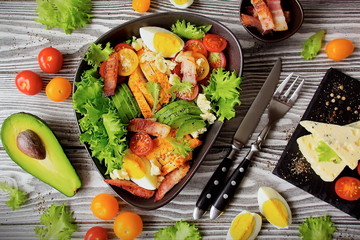 Healthy Cobb Salad. A traditional dish of American cuisine, Cobb Salad with chicken, bacon, avocado and egg. Ingredients for making Cobb salad