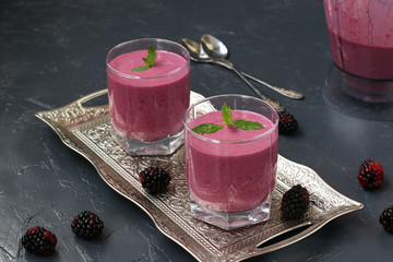 Protein cocktail with cottage cheese and blackberries is located in glasses on a dark background