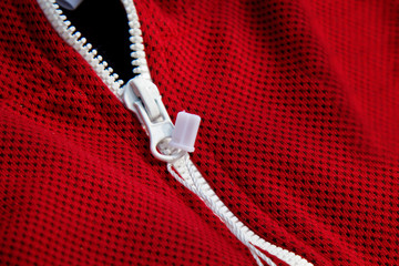 red sportswear closeup top view. white zip line. breathable knitwear. clothing details macro
