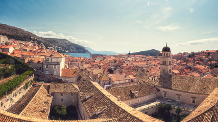 Obraz premium Old City of Dubrovnik red roofs and Franciscan monastery, panoramic view from ancient city wall. World famous and most visited historic city of Croatia, UNESCO World Heritage site, travel background