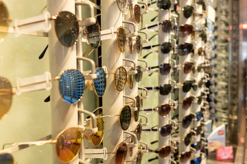 Sunglasses of different colors in a display for glasses in an optical