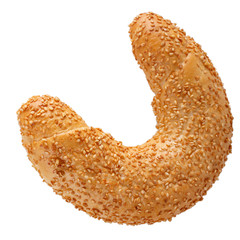 Crescent rolled bun with sesame seeds isolated on white background. Freshly baked bagel close-up.