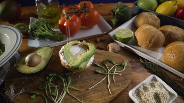 Healthy food. Healthy assortment of vegetables and fruits with legumes: sandwich with avocado and sesame, sprouted grains, fresh bread, lemon, tomatoes, olive oil.