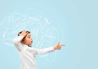 Young caucasian boy with mixed thoughts against blue background. Negative space to insert your text. Concept of thinking confusion, stress out, misunderstanding, facial expression, human emotions.