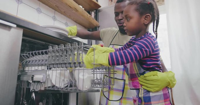 Father And Daughter Loading Dishwasher