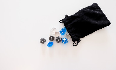 A set of dices for board games and roleplay games falling out of the bag