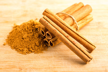 Cinnamon sticks and powder on wooden table