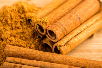 Cinnamon sticks and powder on wooden table