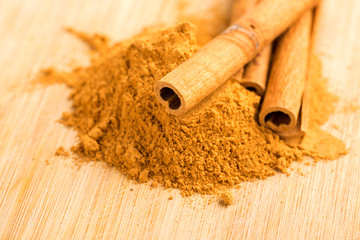 Cinnamon sticks and powder on wooden table