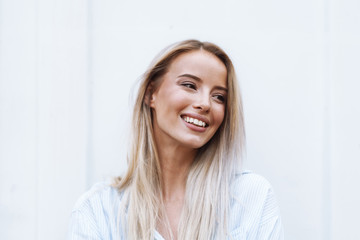 Close up of a smiling young blonde woman standing