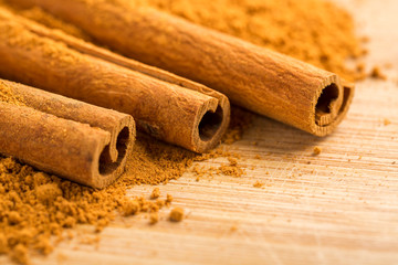 Cinnamon sticks and powder on wooden table