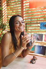 Smiling young woman sitting at the cafe