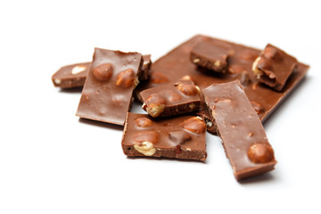 pieces of chocolate with hazelnuts on white background
