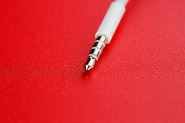 White connector AUX white cable on a red background