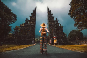 Abwaschbare Fototapete Bali Touristische Frau mit Rucksack im Urlaub zu Fuß durch den Hindu-Tempel in Bali in Indonesien