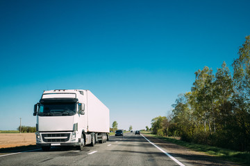 Truck On Country Road. Tractor Unit, Prime Mover, Traction Unit In Motion On Countryside Road In Europe. Business Transportation And Trucking Industry Concept