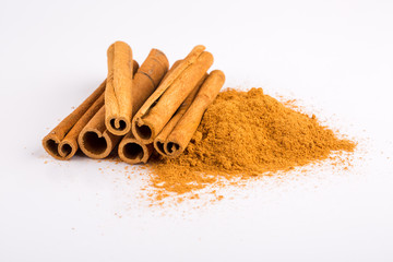 Cinnamon sticks and powder on white background