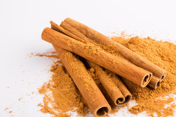 Cinnamon sticks and powder on white background