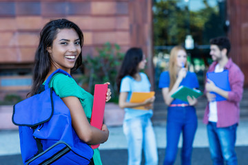 Lachende spanische Studentin auf dem Weg zur Uni