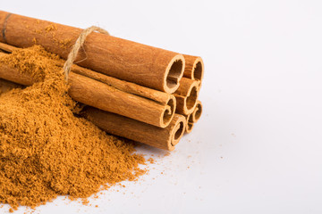 Cinnamon sticks and powder on white background