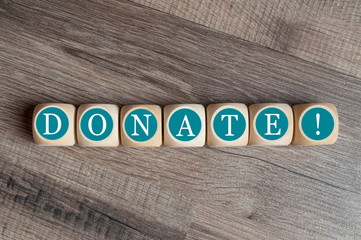 Cubes and dice with donate on wooden background