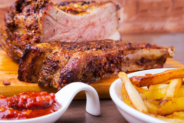 Grilled pork ribs with potato free and sauce on white plate.