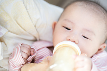Asian baby happy in the room.Asian baby girl lying down on bed .
