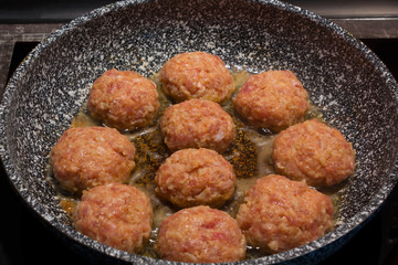 Homemade cooking cutlets in a grey granite frying pan